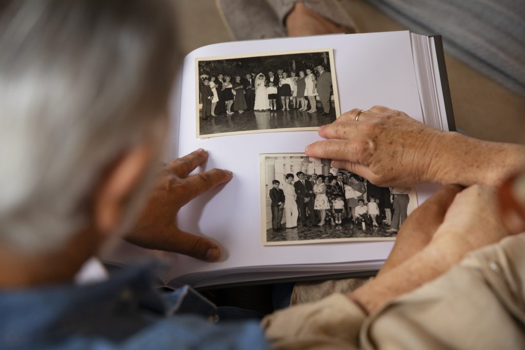 Grandparents look at old photos at a family reunion in Sydney