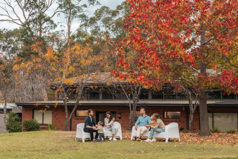 Two couples with their toddlers enjoy the outdoor, communal areas at Long Point Conference Centre.