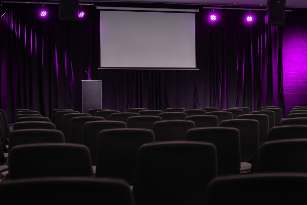 Multi-media auditorium with projector, podium, professional lighting and a sound system.
