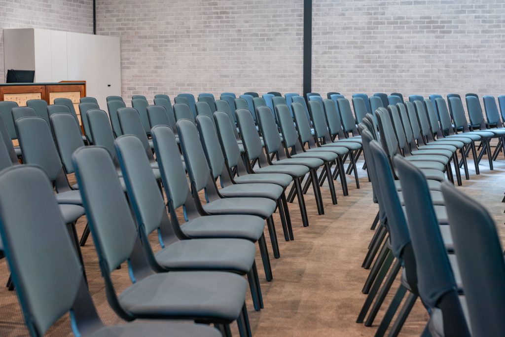 Over 150 chairs are set up in an auditorium in Sydney.