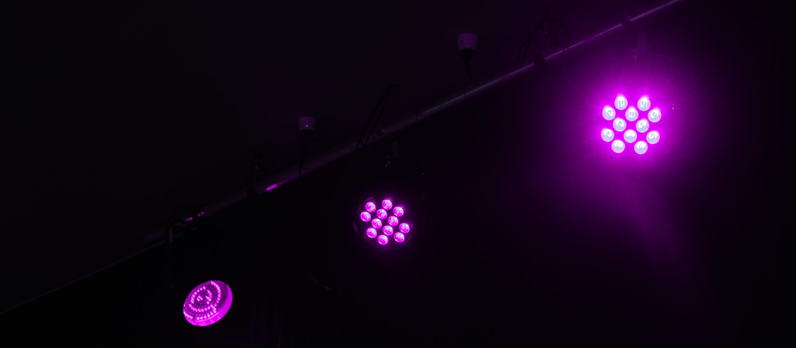 Purple stage lights against a black backdrop set the scene for a business meeting.