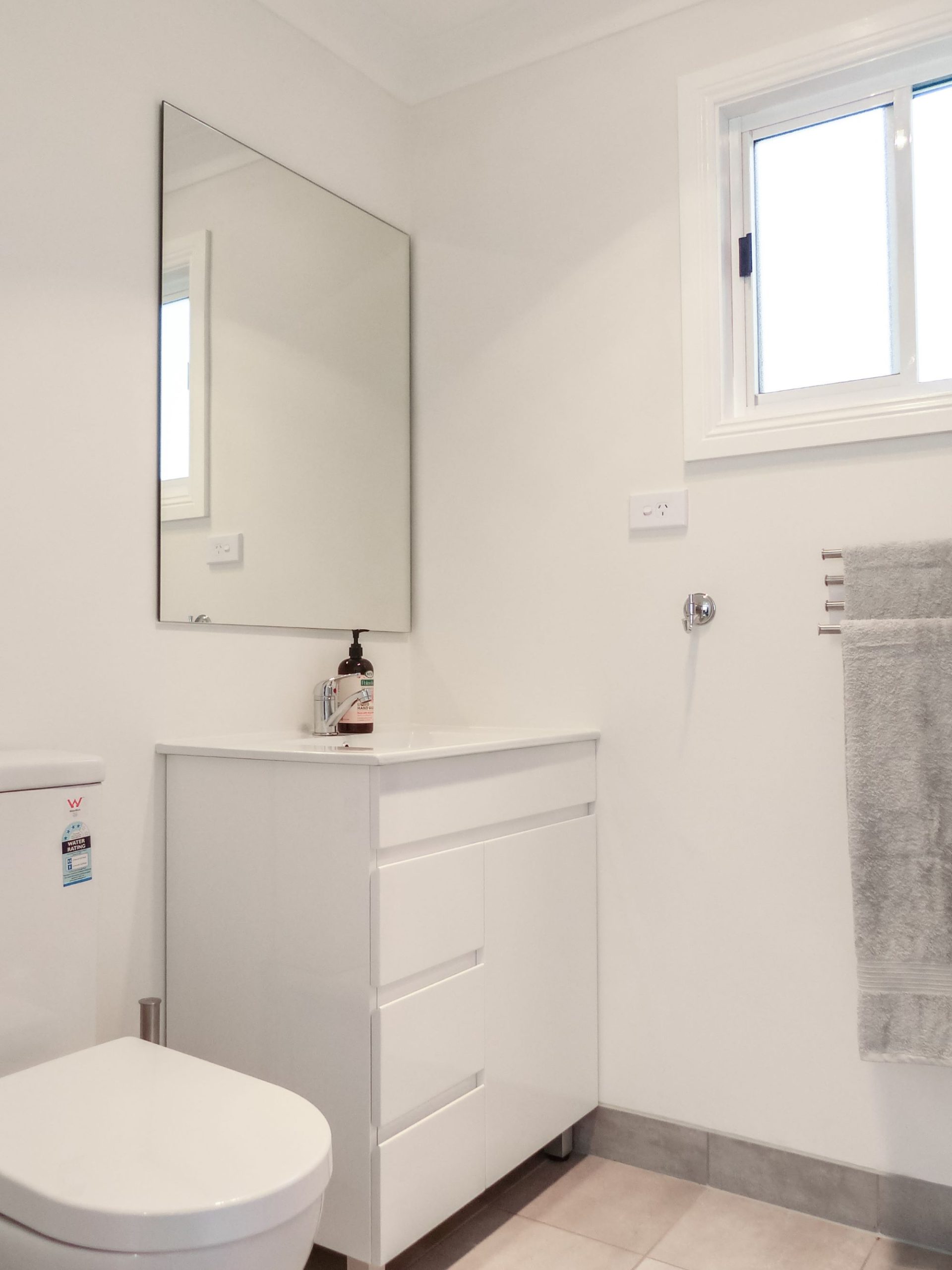 A clean, white bathroom in a cabin at an accommodation venue in Sydney.
